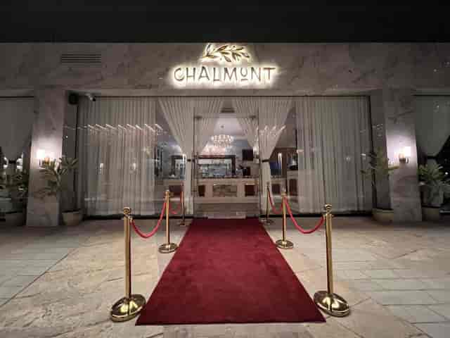 Elegant banquet hall entrance with red carpet and gold stanchions for upscale events.