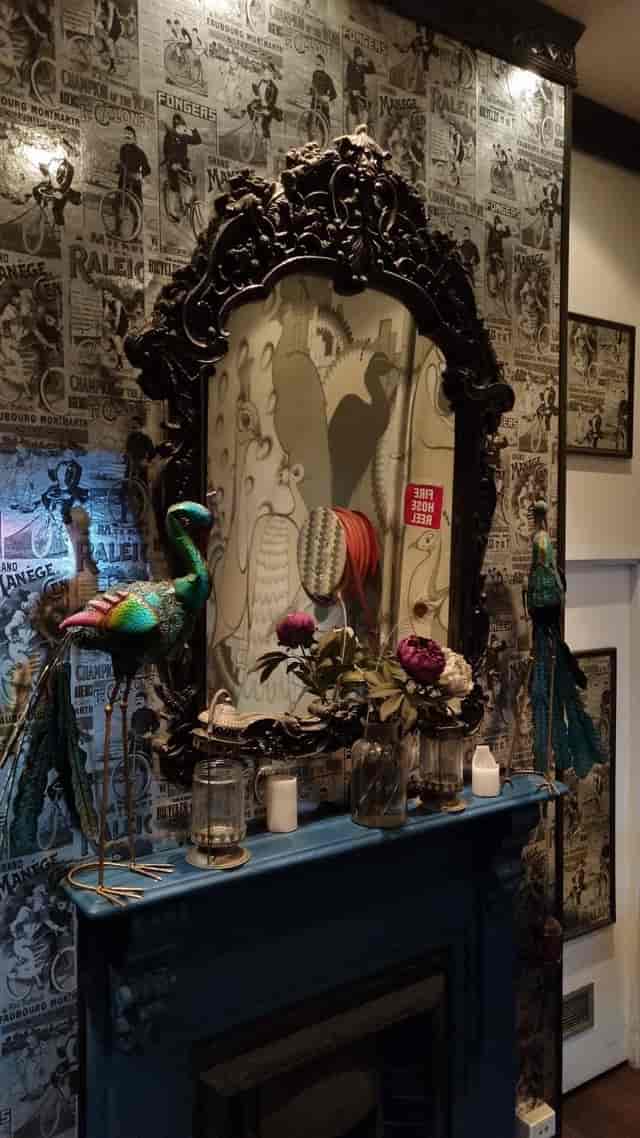 Indoor bar at The Emerald Peacock with ornate mirror, vibrant decor for events.
