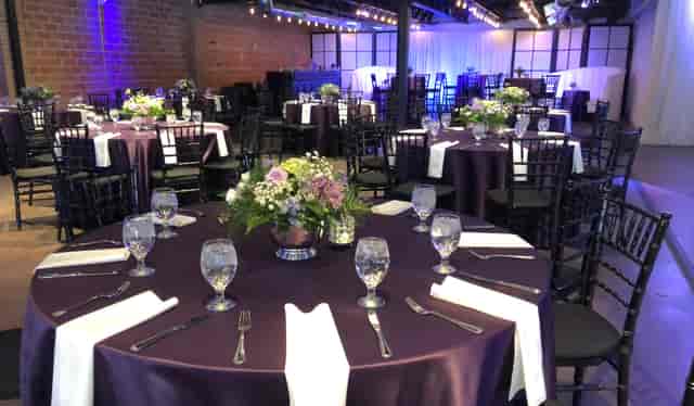 Elegant 3rd Floor Penthouse event space with purple tables and floral centerpieces.