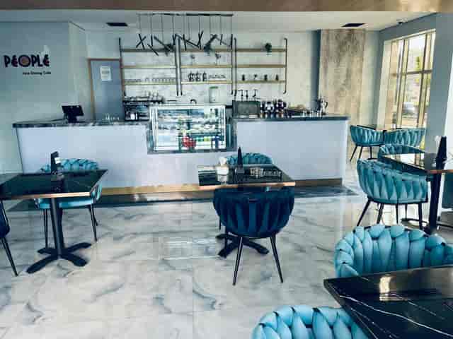 Modern cafe in Al Waha Hotel with elegant blue chairs, ideal for networking events.
