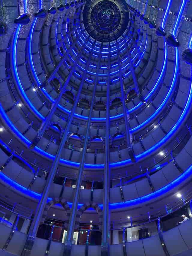 Modern circular hotel room with blue lighting, perfect for events and conferences.