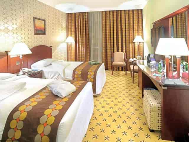 Twin beds in a hotel room at LEADER Al Muna Kareem, perfect for meetings and events.