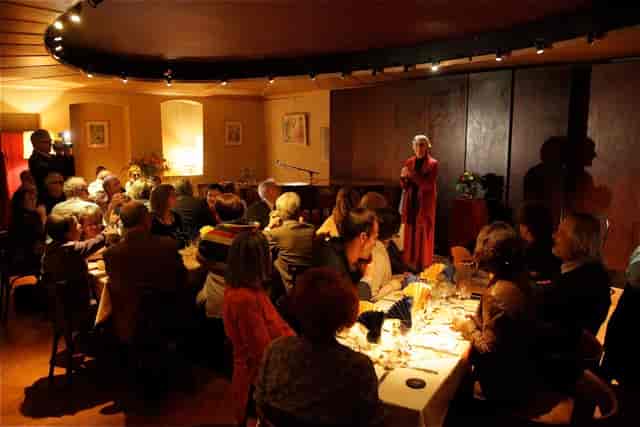 Elegant dinner event at Le Café des Arts with engaging speaker in warm ambiance.