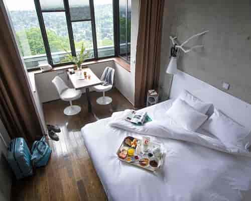 Stylish hotel room at La Maison, featuring a cozy bed for retreats and meetings.