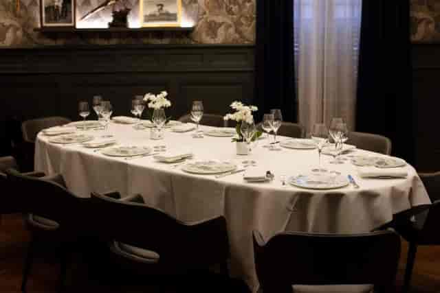 Upscale dining table with floral centerpieces at Auberge du Pont de Collonges event.