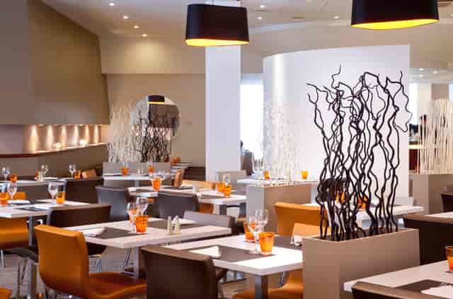 Modern dining space at Novotel Lyon, ideal for events and meetings, featuring ample natural light.