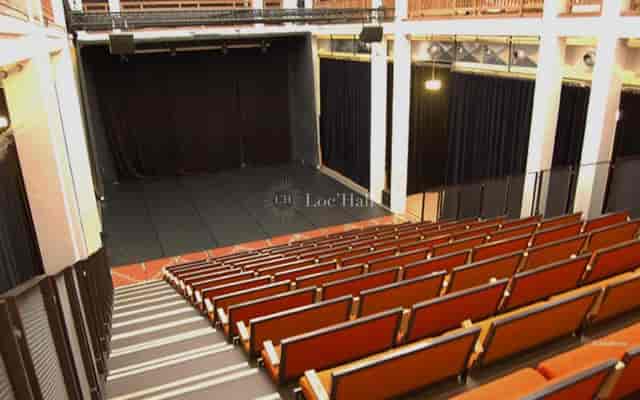 Auditorium in Palais de la Porte Dorée with tiered seating for events and performances.