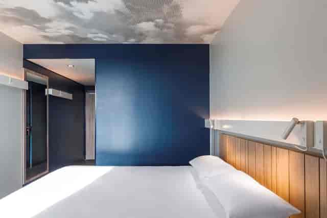 Modern hotel room with blue accent wall, ideal for small group events and retreats.