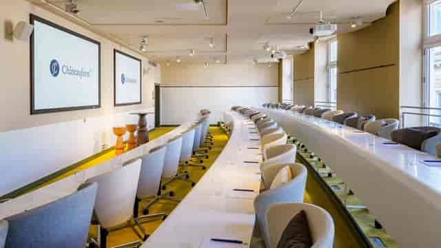 Modern meeting room with curved seating, ideal for corporate events and workshops.