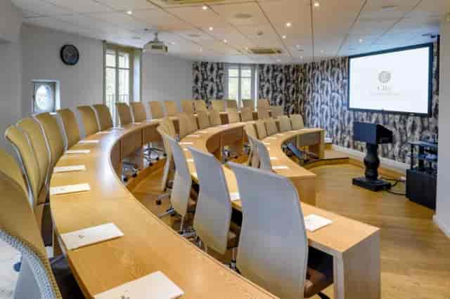 Modern meeting space at Châteauform' with semi-circular seating for corporate discussions.