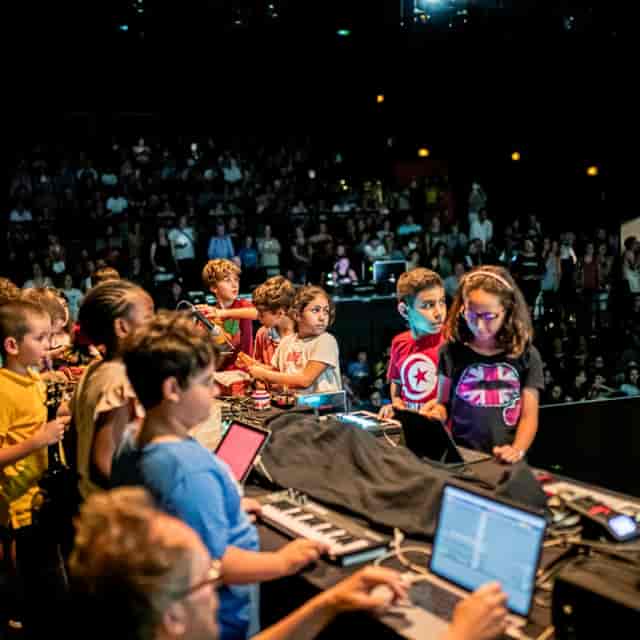 Children performing on stage at Les Abattoirs SMAC music event, showcasing creativity and engagement.