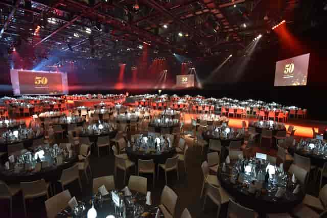 Eurexpo Lyon auditorium set for formal dinner with elegant table settings and stage.
