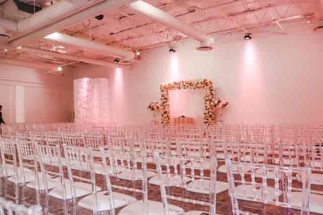 Elegant Nuvo Room wedding banquet hall with floral arch and transparent chairs.