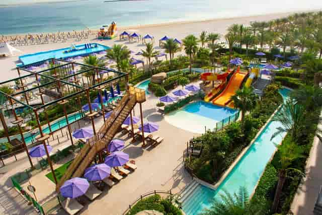 "Vibrant BLU Oasis pool area with slides for corporate retreats and leisure events."