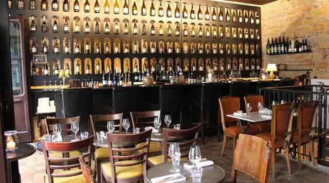 Warm Bistro setting with unique bottle display, ideal for intimate dining or corporate events.