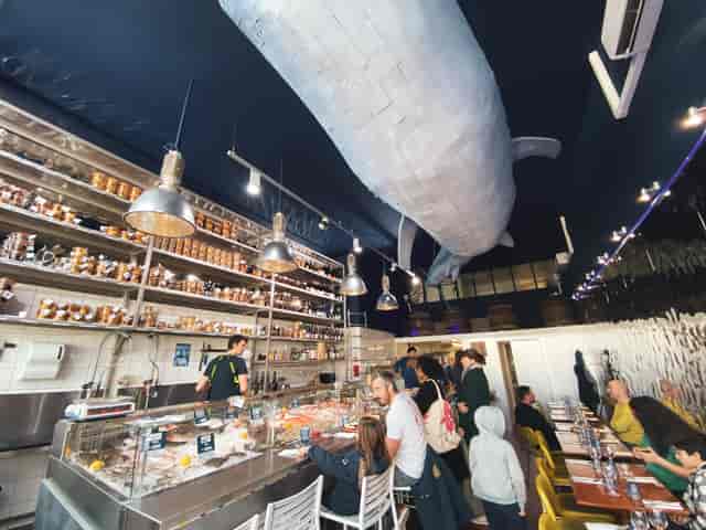 Seafood restaurant with whale ceiling art, perfect for private or corporate gatherings.
