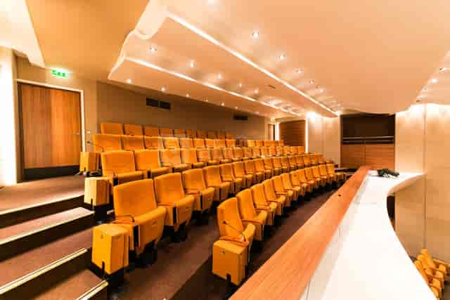 Auditorium at Maison de l’Artisanat with tiered seating, ideal for meetings and presentations.