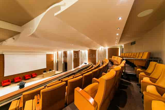 Modern auditorium with tiered seating for meetings and events at Maison de l’Artisanat.