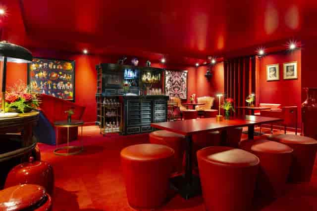 Stylish red lounge at Le Royal Lyon hotel for cocktail receptions and gatherings.