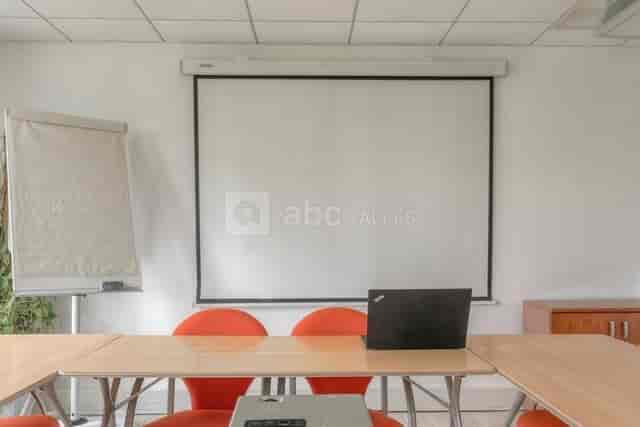 Clean training room with large screen, ideal for presentations and workshops.
