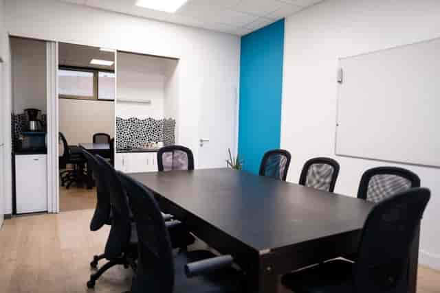 Modern conference room with large table, ergonomic chairs, ideal for meetings and events.