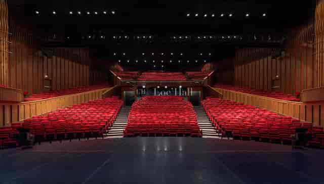 Grande Salle in Maison de la Danse with tiered red seats, perfect for conferences and performances.