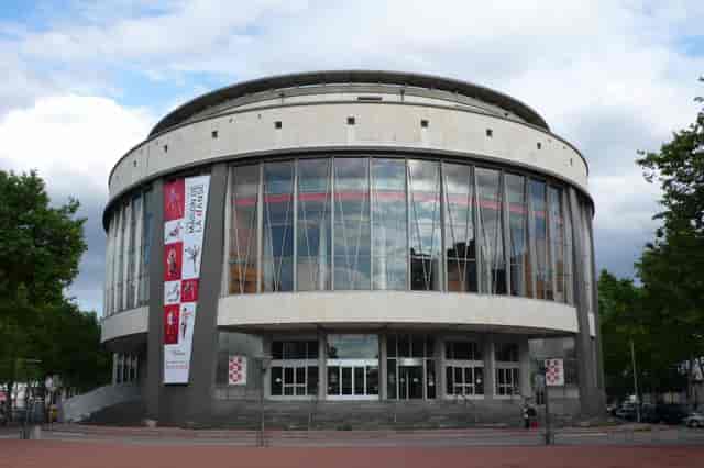 Modern theater with circular architecture, large windows for performances and events.