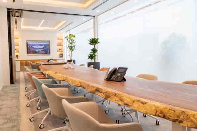 Modern boardroom with wooden table, ideal for meetings and presentations. 