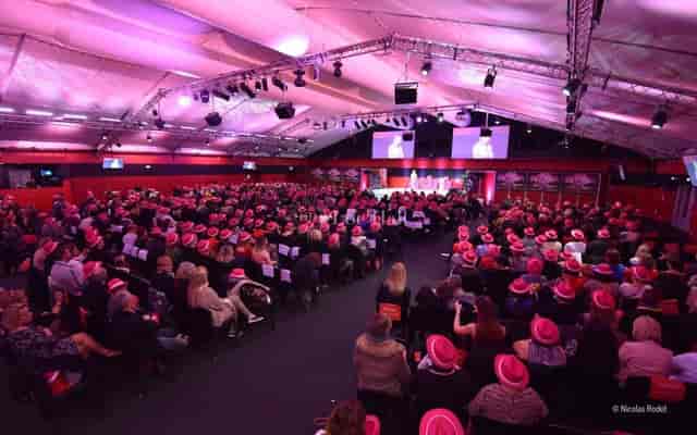Vibrant event at Matmut Stadium with attendees in pink hats, perfect for networking.
