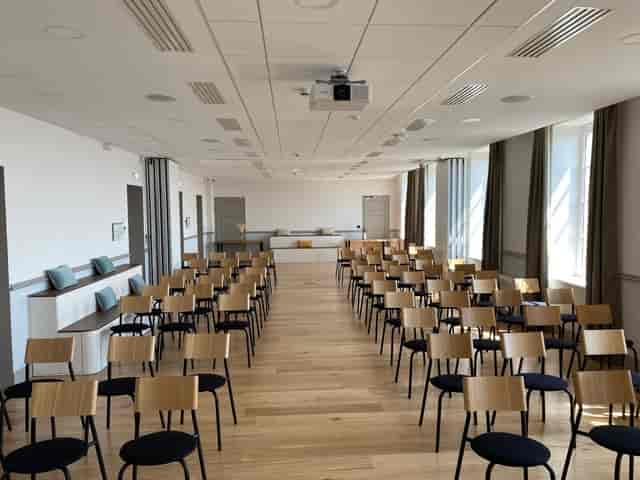 Conference room in Carré Fourvière with wooden chairs, ideal for seminars and workshops.