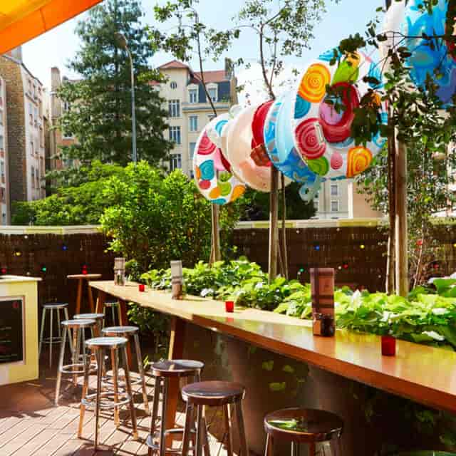 Vibrant outdoor event space at Mama Shelter Lyon with colorful decor and bar seating.