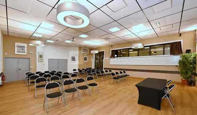 Meeting space in Salle Cers, with black chairs for workshops and presentations.