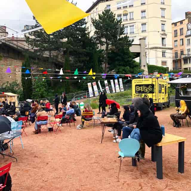 Outdoor event space at La Friche Lamartine with colorful seating and food trucks for networking.