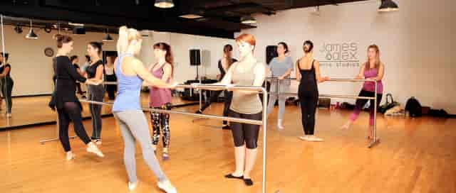 Group of dancers practicing ballet in a bright dance studio, perfect for workshops and classes.