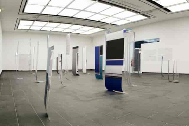 Minimalist gallery space with suspended signage for trade shows and art exhibitions.