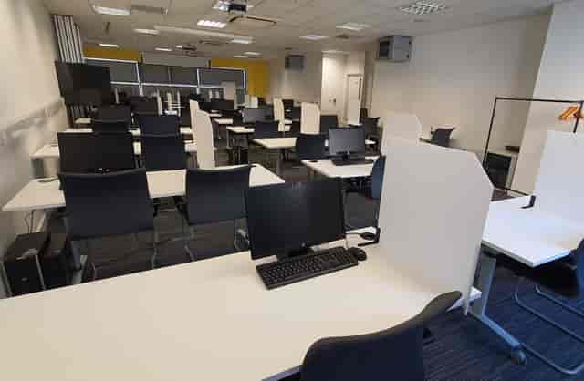 Modern IT test centre workspace with computers, ideal for corporate workshops and training.