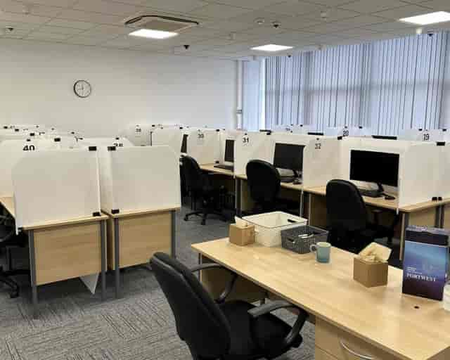 Modern test center setup with cubicles, ideal for IT exams and hybrid meetings.