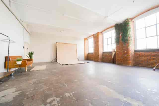 Spacious portrait studio with natural light for creative events and meetings.