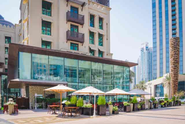 Modern La Serre restaurant with glass facade, perfect for outdoor events and dining.