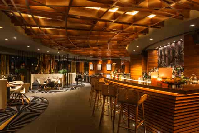 Sophisticated Zengo bar with warm wood accents for upscale events and networking.