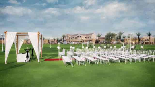 Elegant outdoor birthday setup at Dubai Polo & Equestrian Club with white chairs and palm trees.
