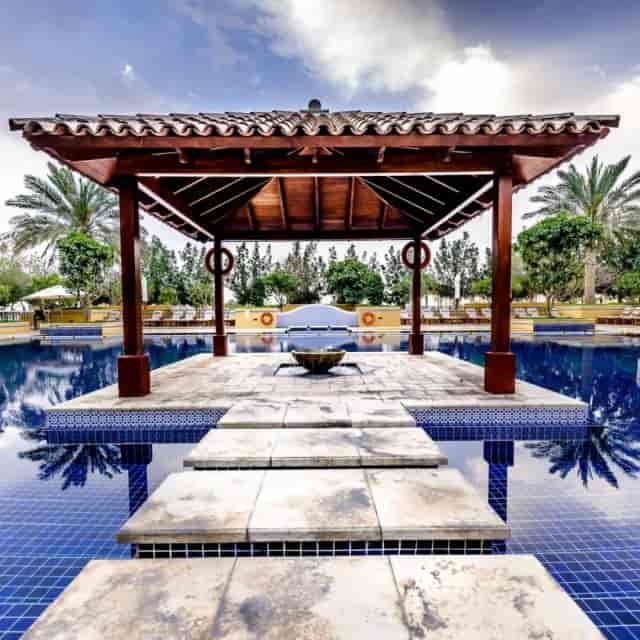 Serene Dubai polo venue with pavilion by tranquil pool for upscale events and receptions.