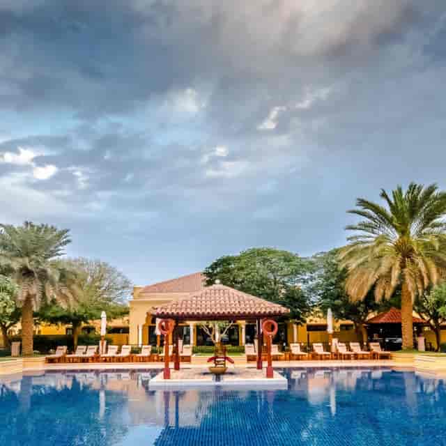 Pool Lawn at Dubai Polo Club: spacious gazebo, lush palms; perfect for events and gatherings.