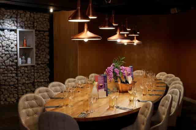 Elegant dining space at The Root, featuring a long wooden table for events.
