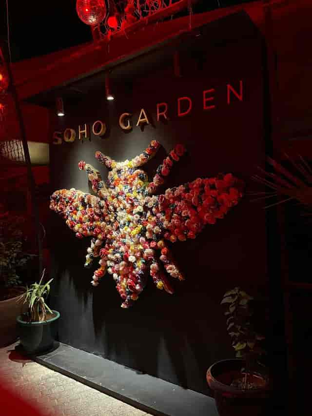 Vibrant bee floral installation in Soho Garden, perfect for events and photography.