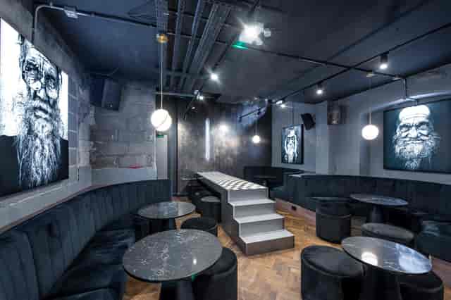Stylish live music bar with modern seating and vibrant wall art, perfect for events.