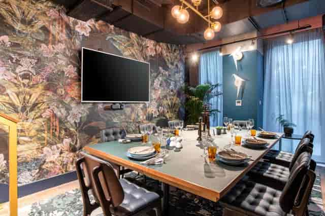 Modern meeting room with floral wallpaper, perfect for small events and gatherings.