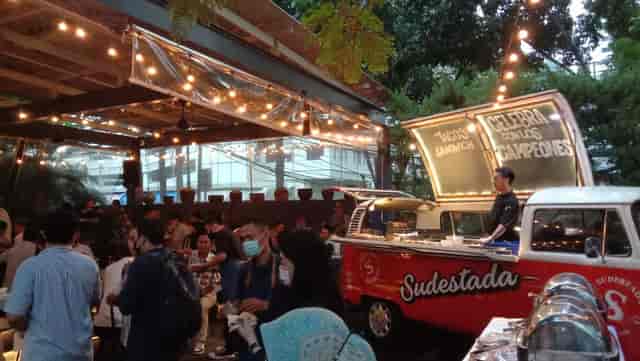 Outdoor event at Sudestada with string lights, food truck, greenery for networking.