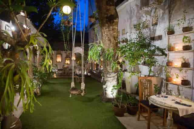 Outdoor bar at Zibiru Restaurant with lush greenery, ideal for intimate events.
