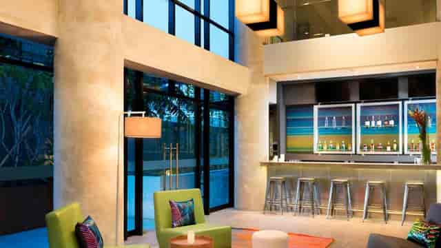 Modern lounge for meetings in Aloft Jakarta, featuring natural light and cozy seating.